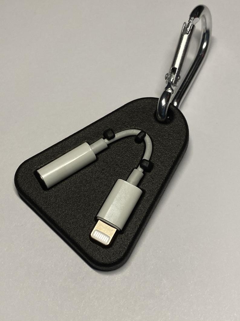 The triangular case, which has latches to hold onto the dongle and is on a keychain