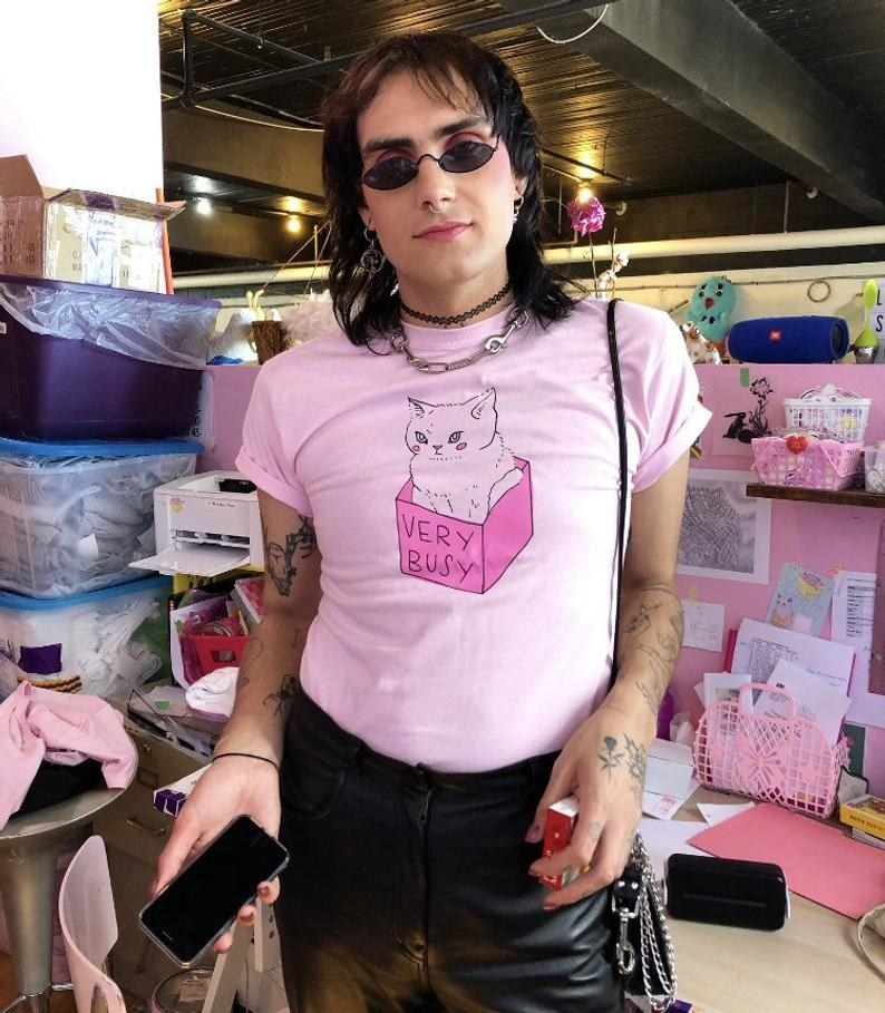 model wearing a pink shirt with a cat in a box on it that says &quot;very busy&quot; 