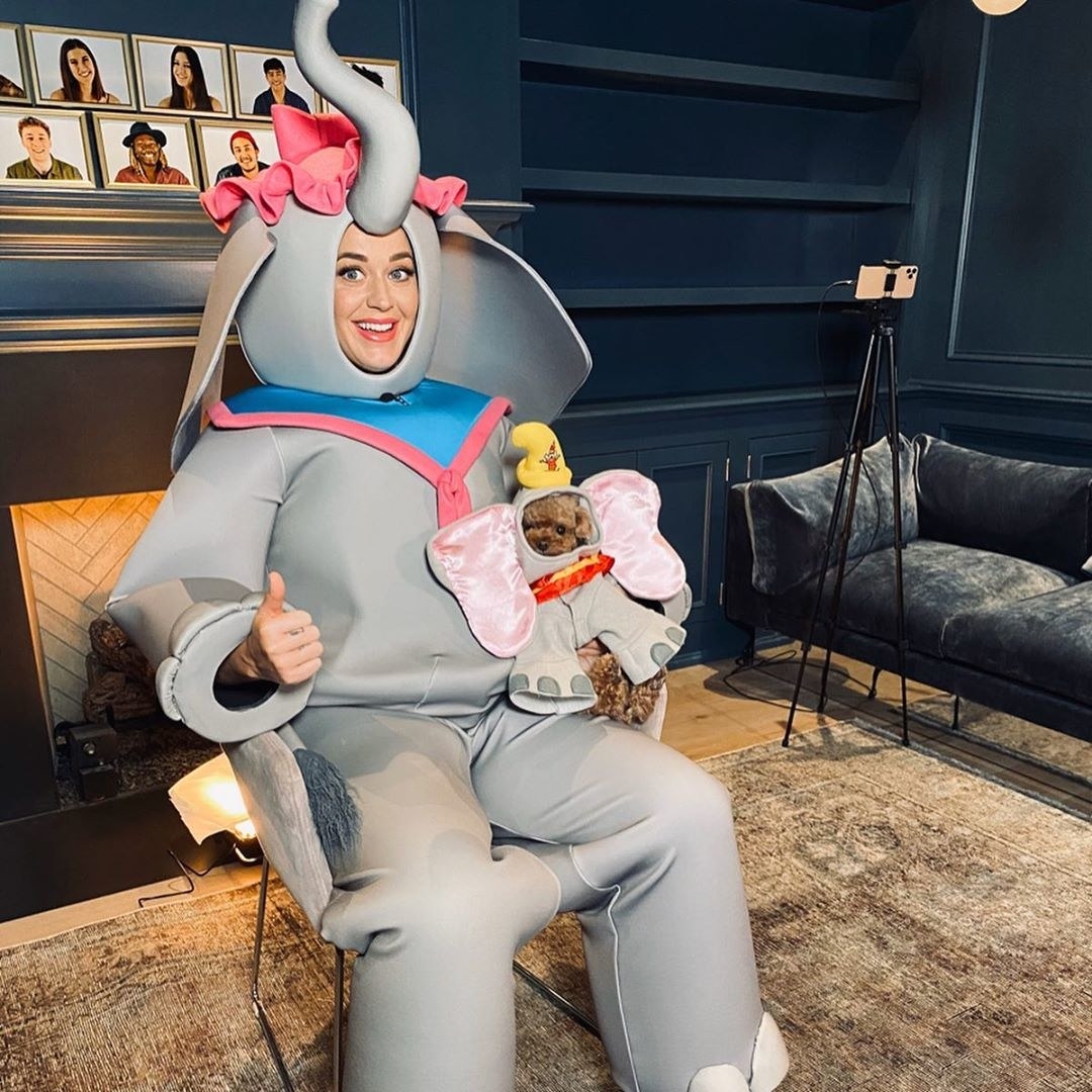 Katy posing with a dog dressed as Dumbo