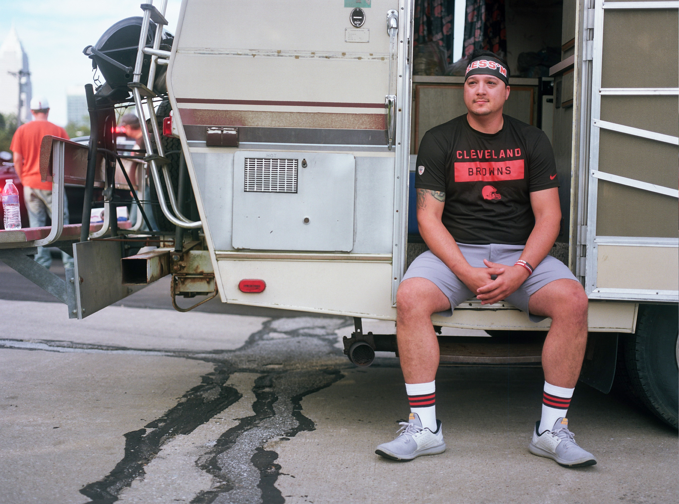 A man sits in a camper van with a Cleveland Browns T-shirt