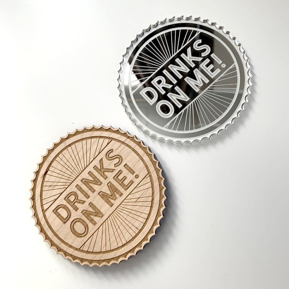 Two coasters that say, &quot;drinks on me!&quot;