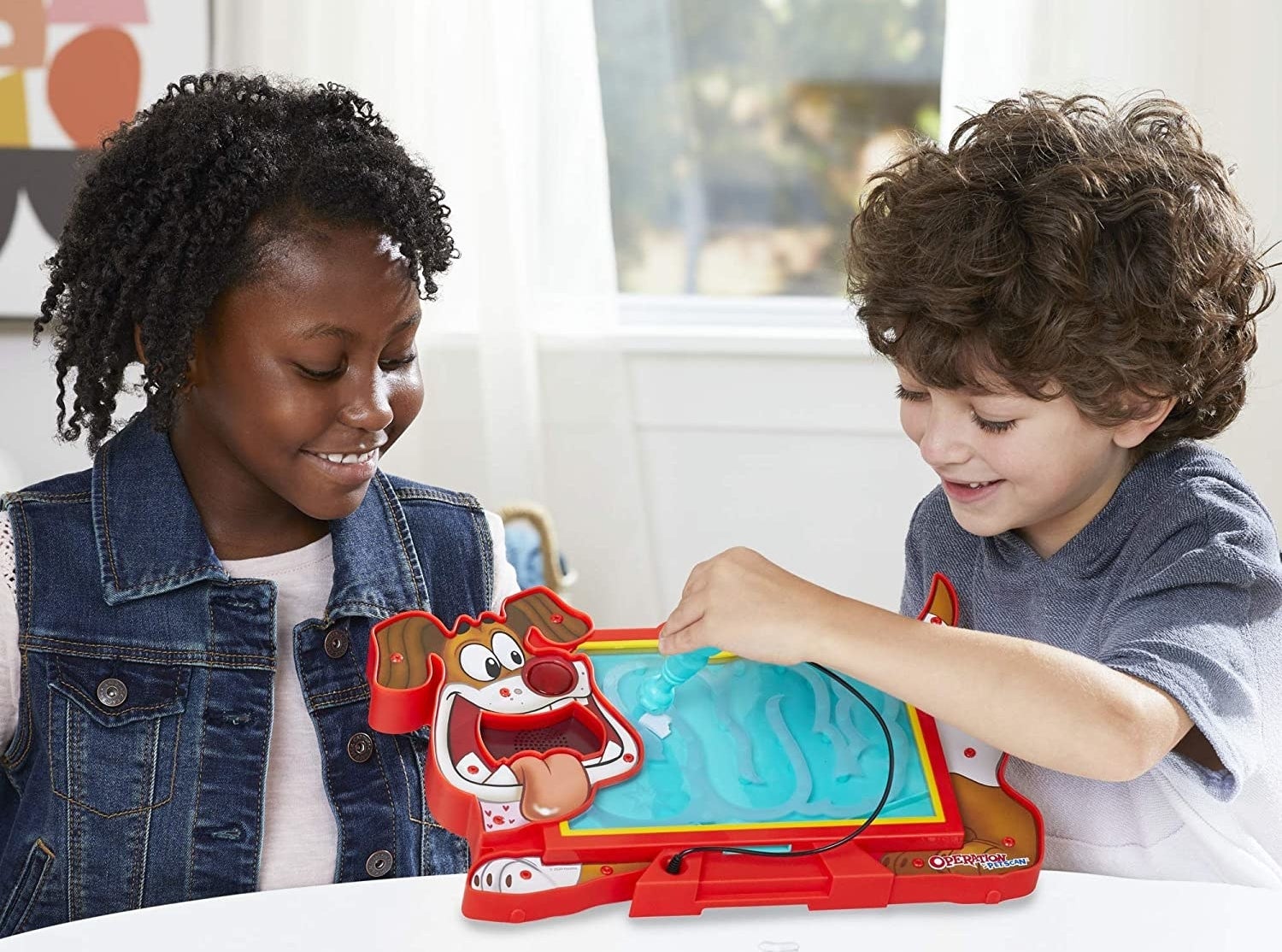 Two child models playing with dog-shaped Operation game