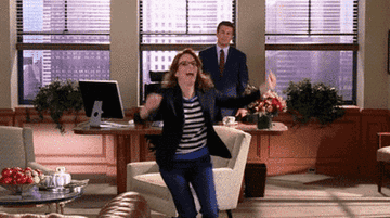 a gif of liz lemon running excited with her arms up