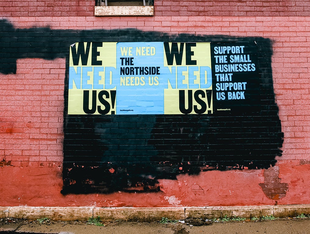 A painted wall saying "We Need Us — the North Side Needs Us"