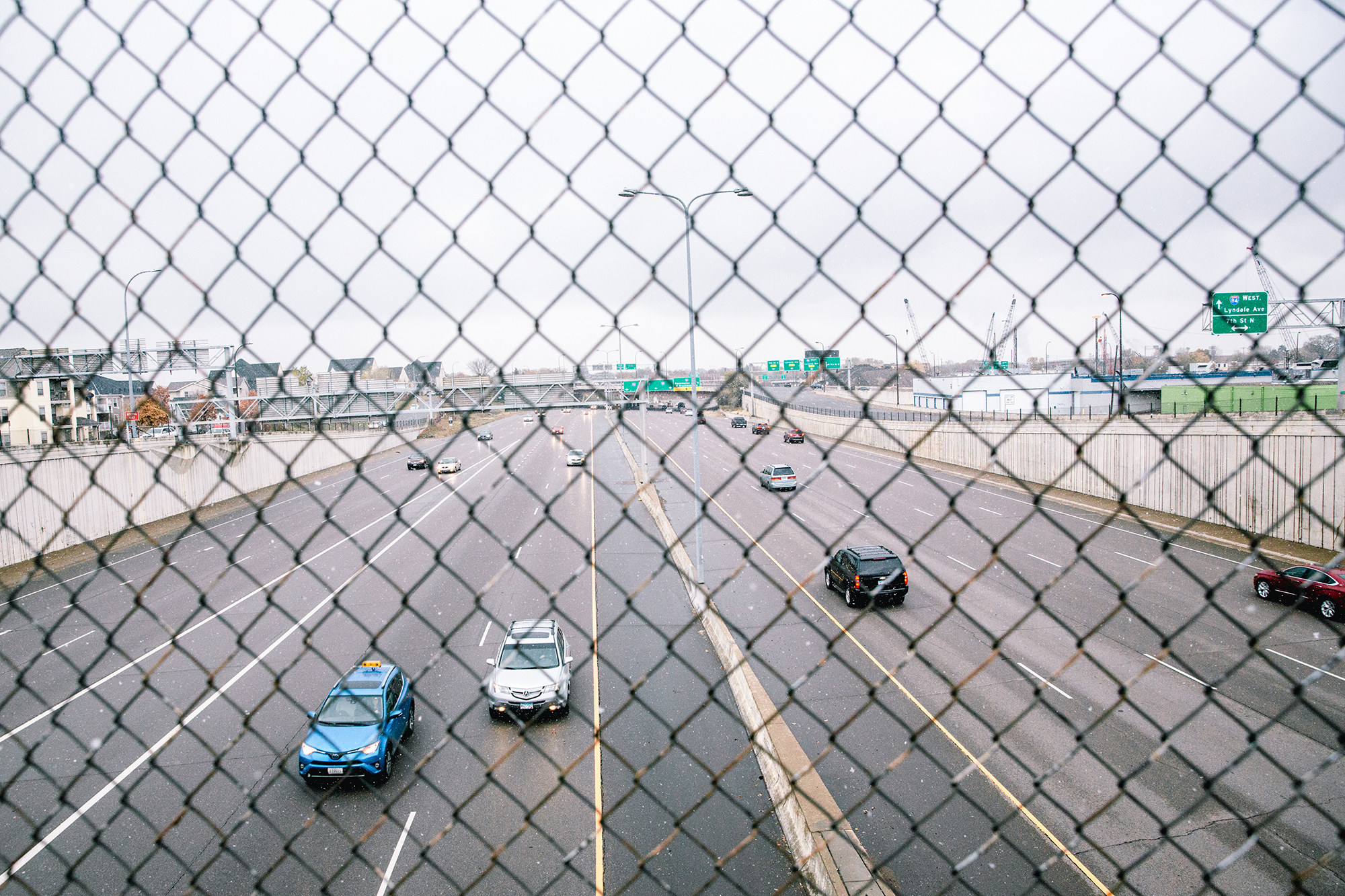 A highway is seen through chain-link fence