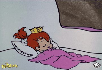 Pebbles from the Flinstones sleeping with a crown on her head 