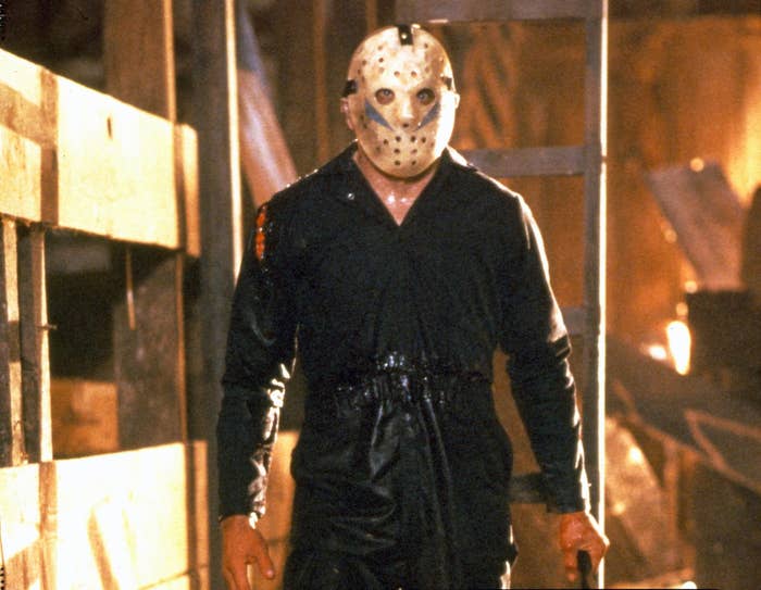 Jason Voorhees in a hockey mask standing in a barn