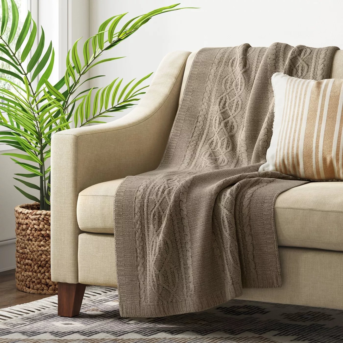 A tan blanket draped over a living room couch