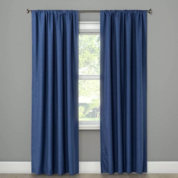 A blue curtain hanging over a glass window