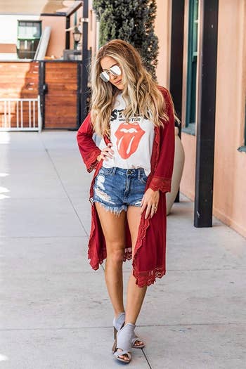 A model wearing the red version, which hits below the knee, over a band tee and shorts