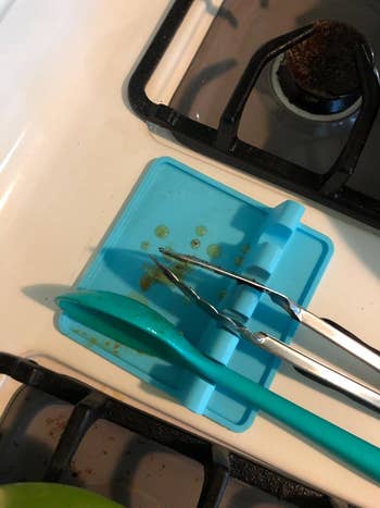 A different reviewer's photo of a blue drip pad holding various utensils