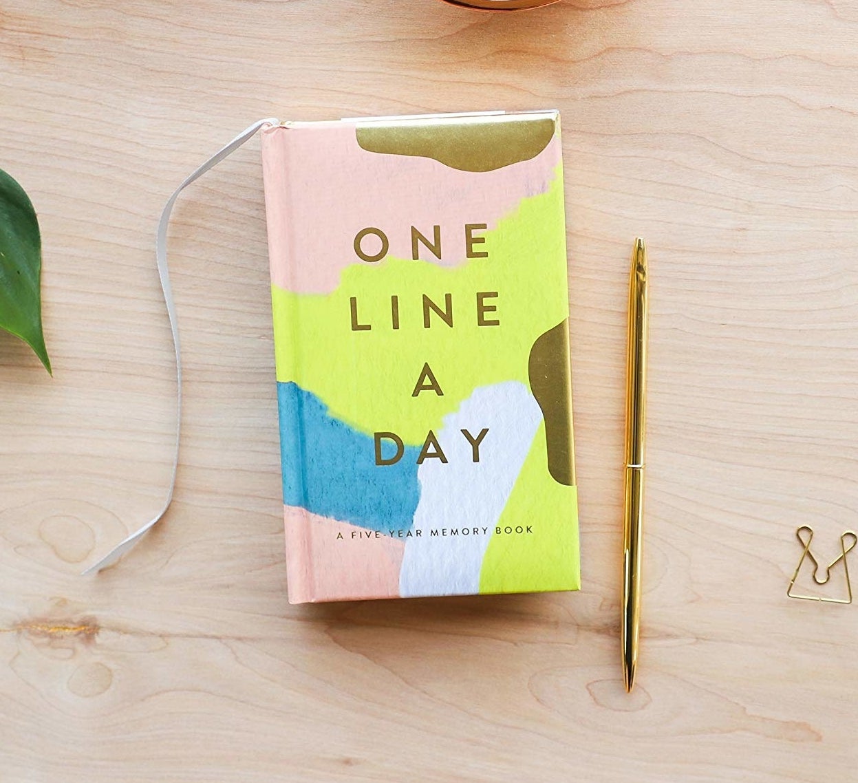 the pink, white, blue, and yellow one line a day journal
