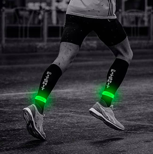 Model wears green glow-in-the-dark bands on their ankles while they run at night