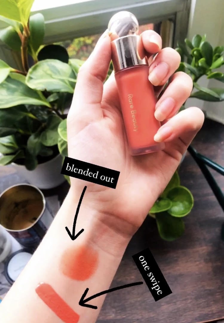 A person holding the blush with two swatches on their arm