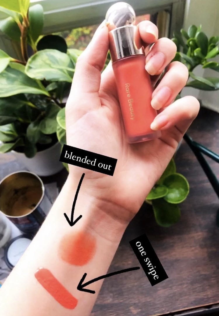 A person holding the blush with two swatches on their arm