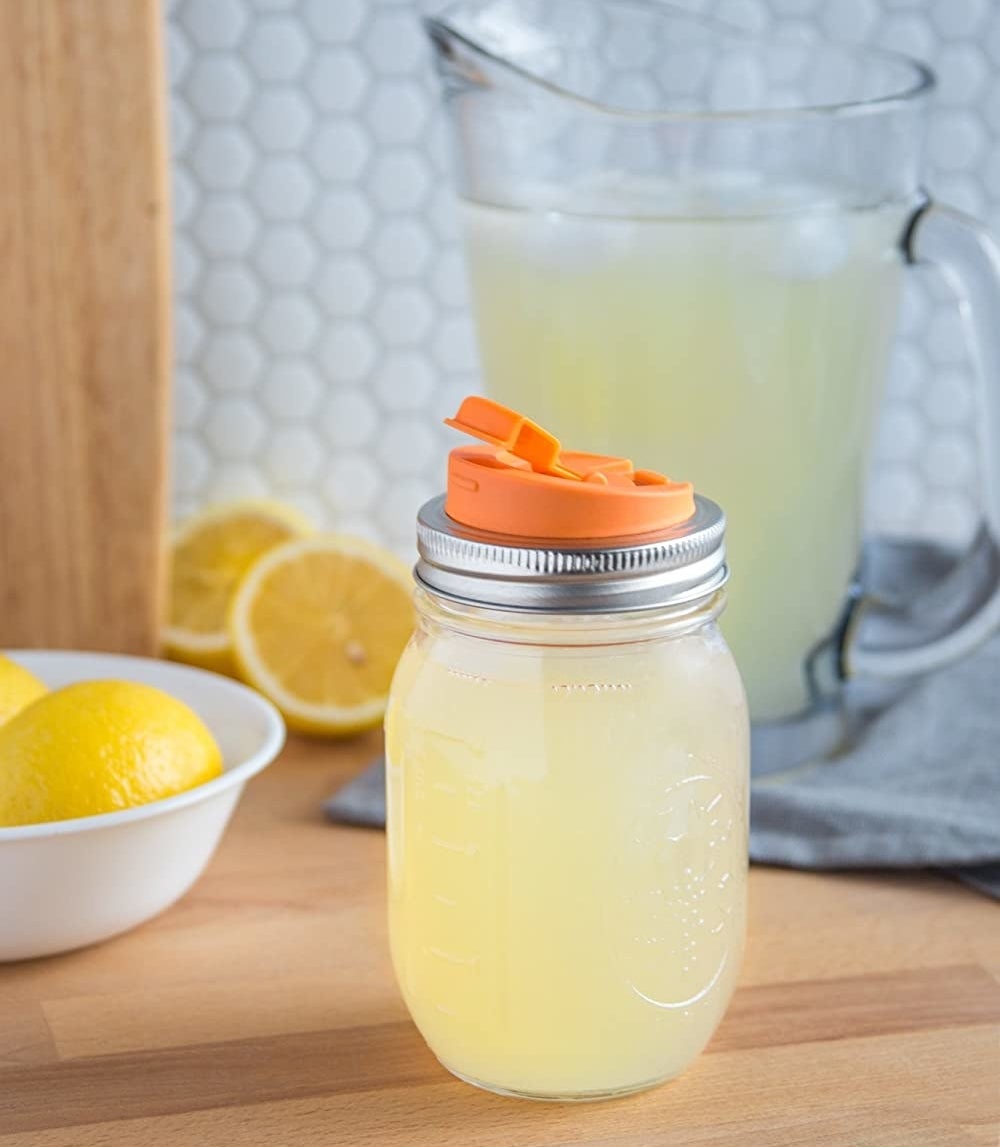 A Mason filled with lemonade that has a spout attached to the lid