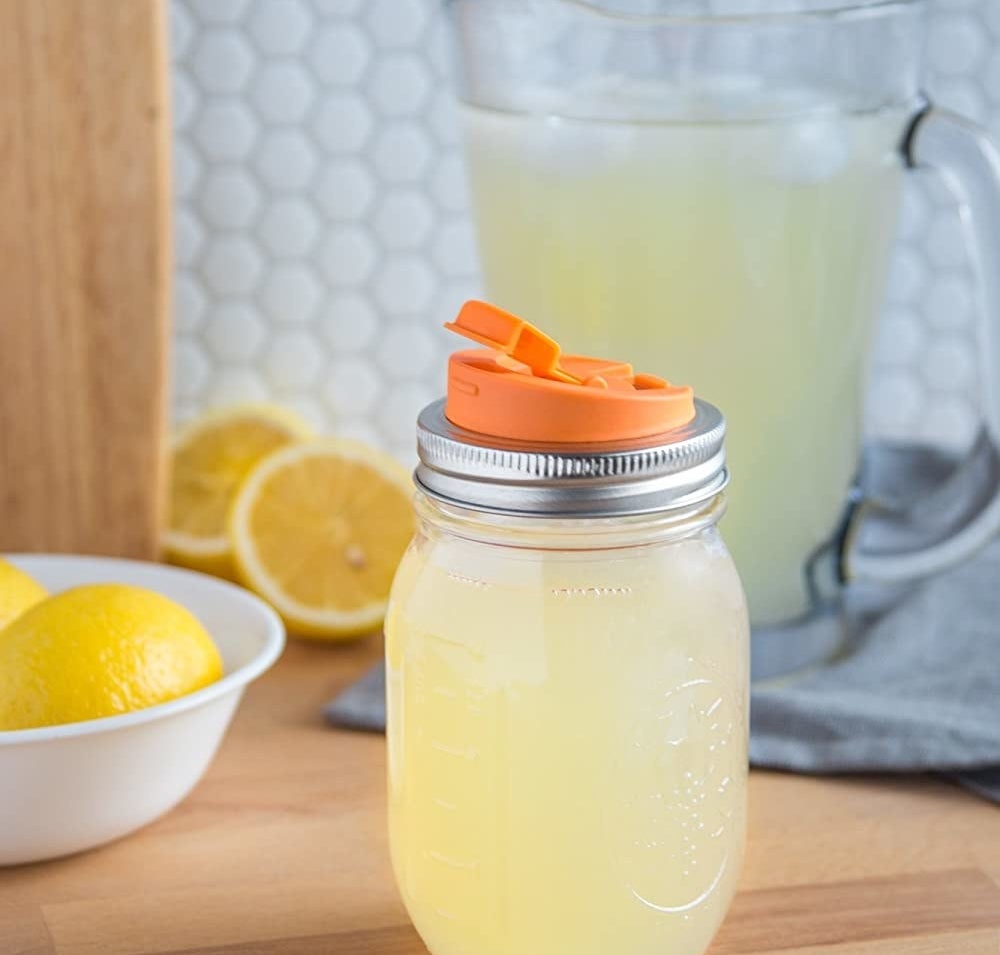 A Mason filled with lemonade that has a spout attached to the lid