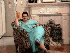 A GIF of a woman reclining in a chair holding a drink