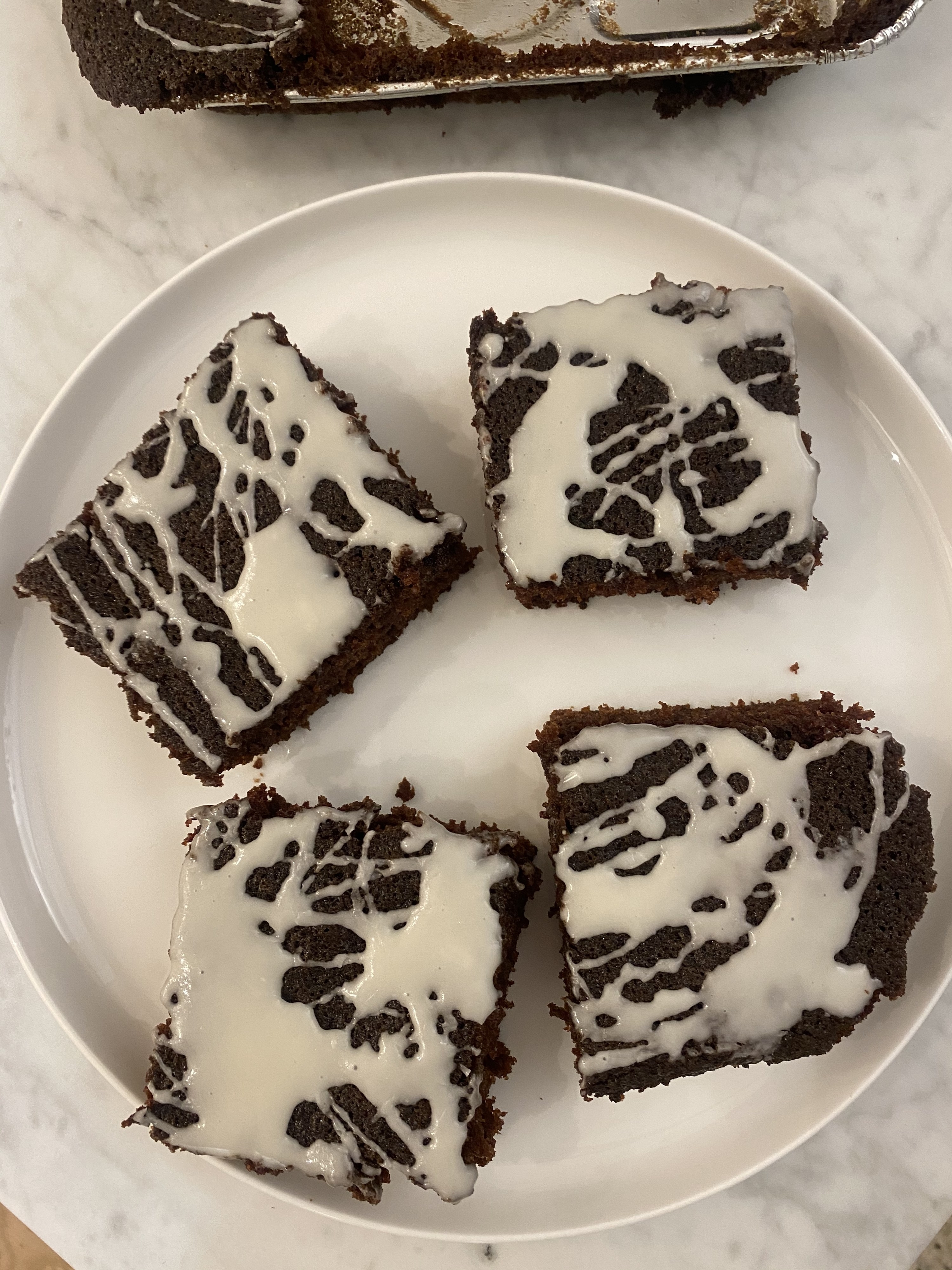 Four slices of nana&#x27;s devils food cake with icing on a plate.