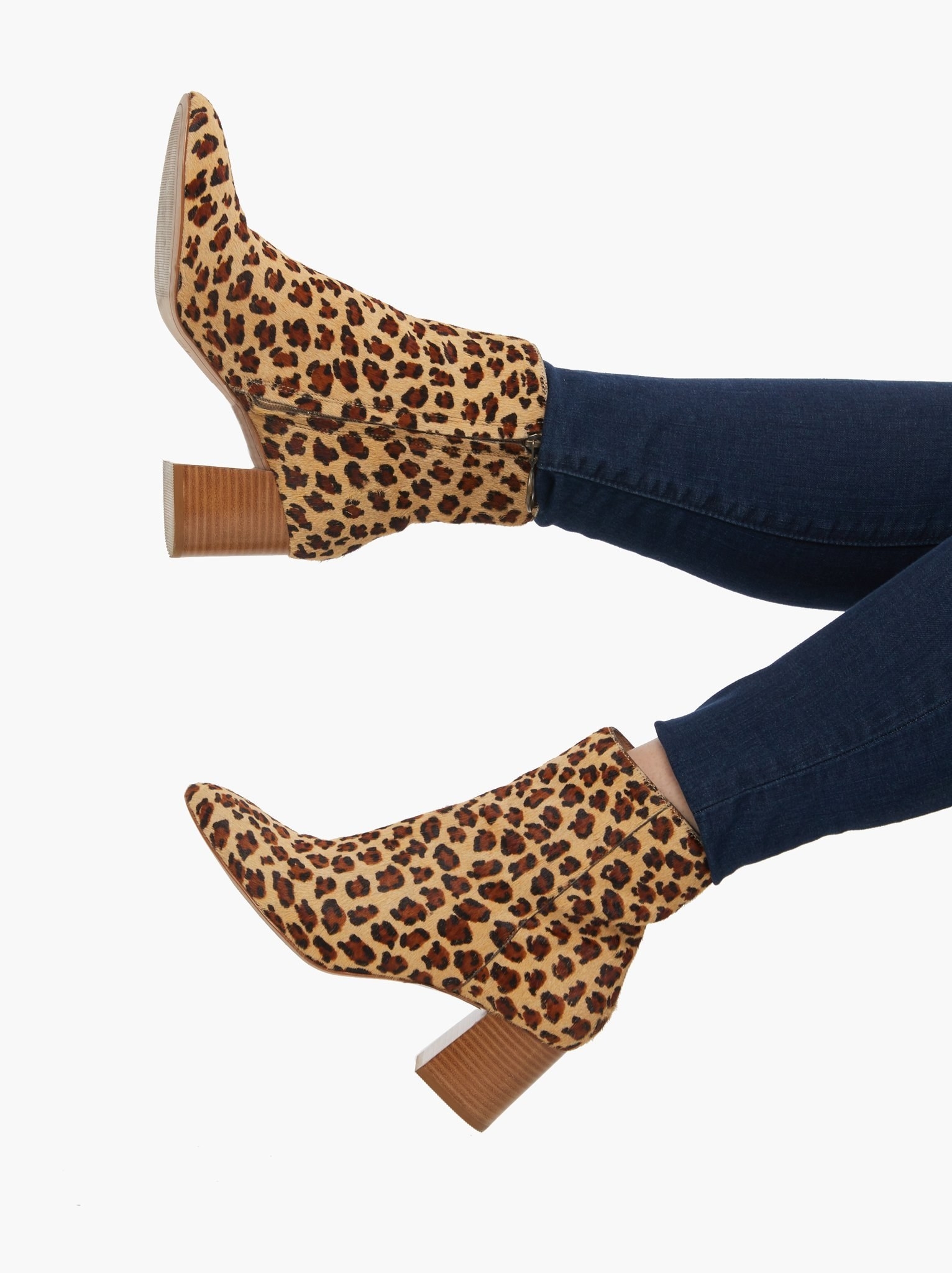 Model wearing the cheetah-print boots with a brown block heel