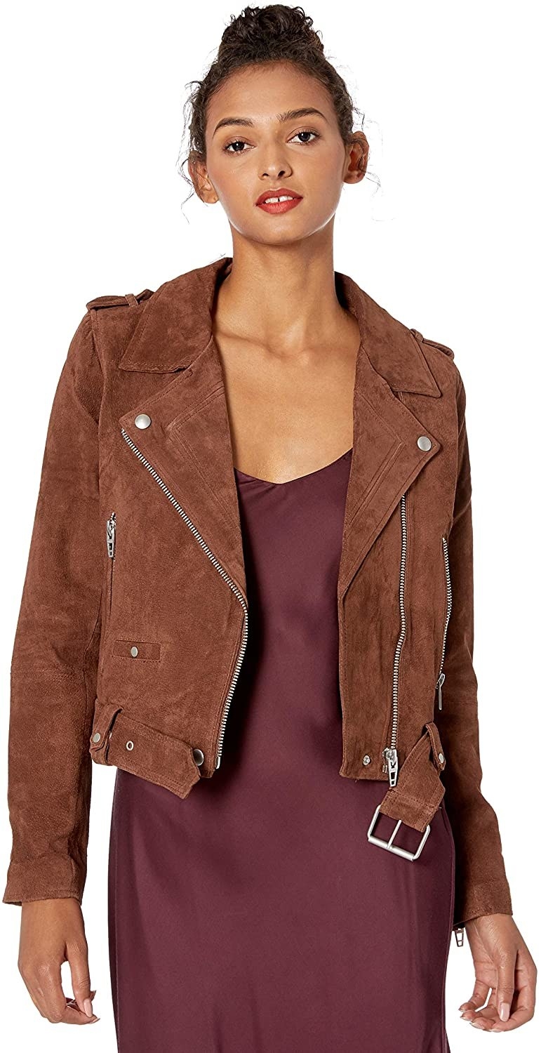 Model wearing the suede jacket with a belt around the bottom and zipper in brown