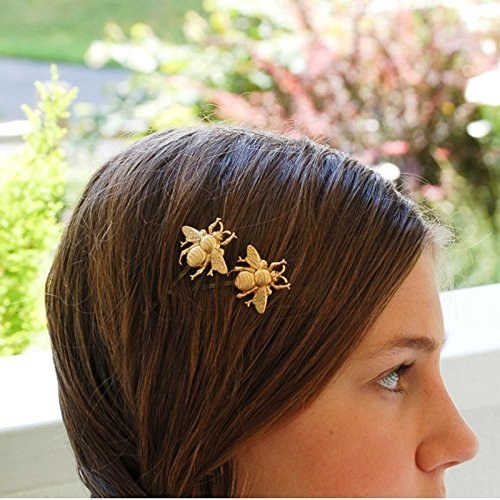 A model wearing the gold bee hairpins