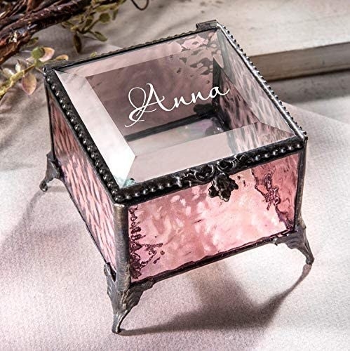 A square shaped pink and glass jewelry box with the name Anna on the top