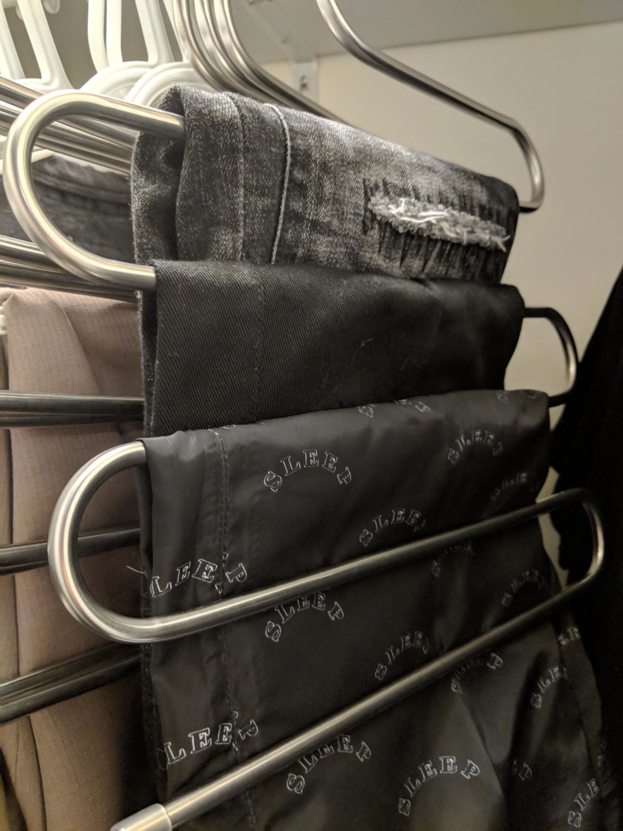 Reviewer image of three pairs of pants hanging from the rod
