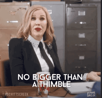 Woman sitting at a desk saying &quot;no bigger than a thimble&quot;