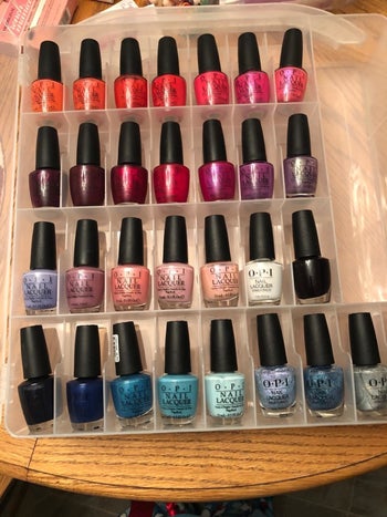 The same organizer, opened to reveal nail polish bottles in every compartment