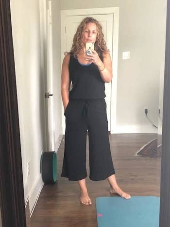 A mirror selfie of a reviewer wearing a black wide-leg jumpsuit