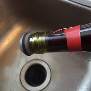 Reviewer image showing leakproof quality of wine stopper with bottle held upside down