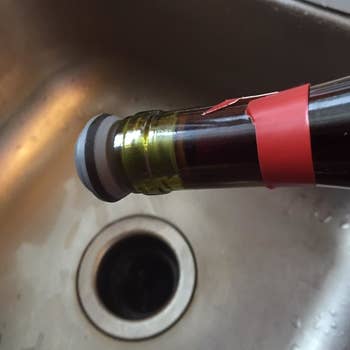 Reviewer image showing leakproof quality of wine stopper with bottle held upside down