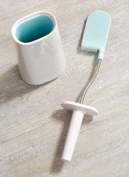 A flatlay of the toilet brush to show off its unusual flat, curved shape