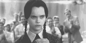 Wednesday Addams drinking a poison bottle in The Addams Family
