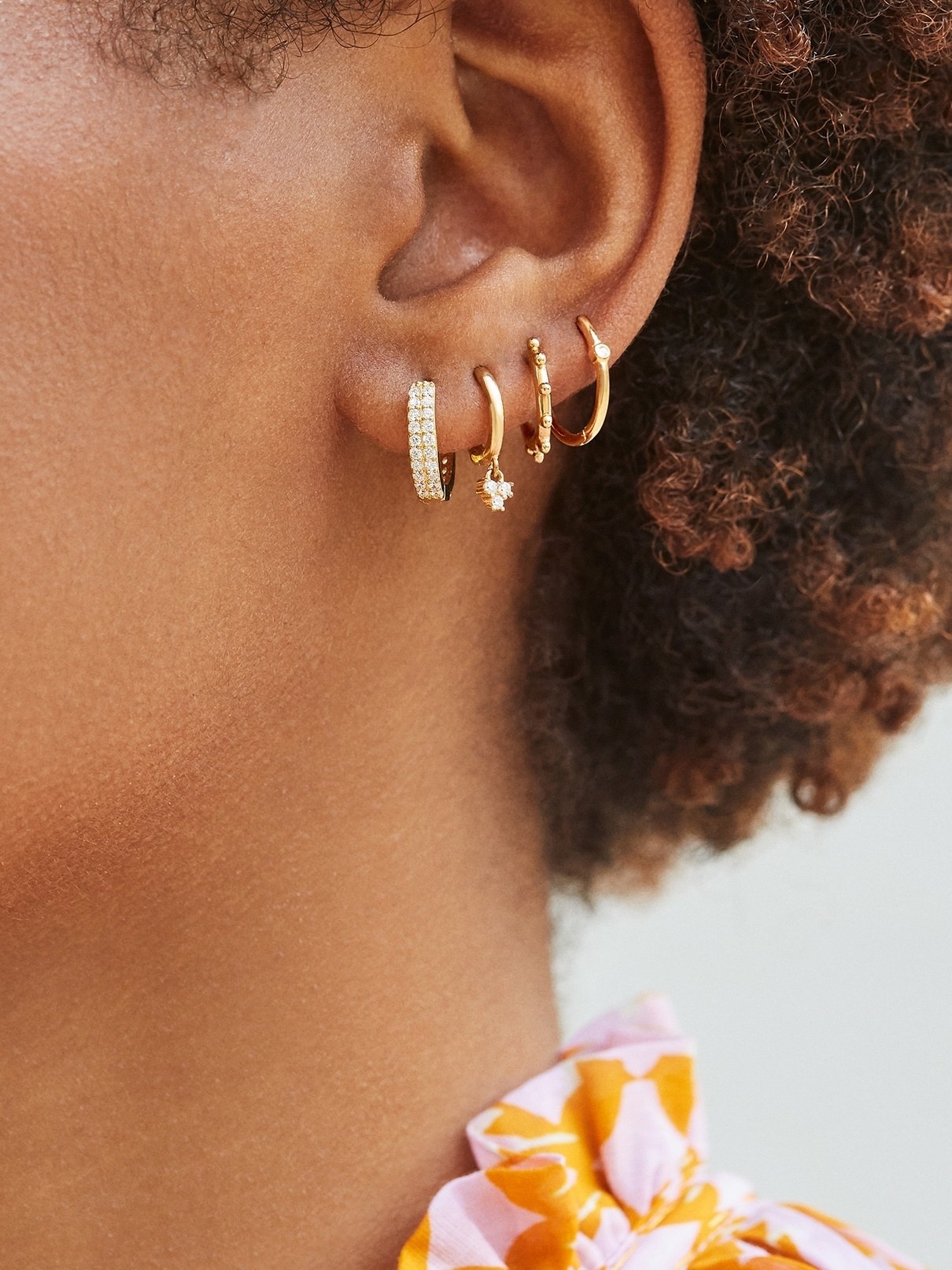 Model wears 18K gold vermeil huggie hoop earring set
