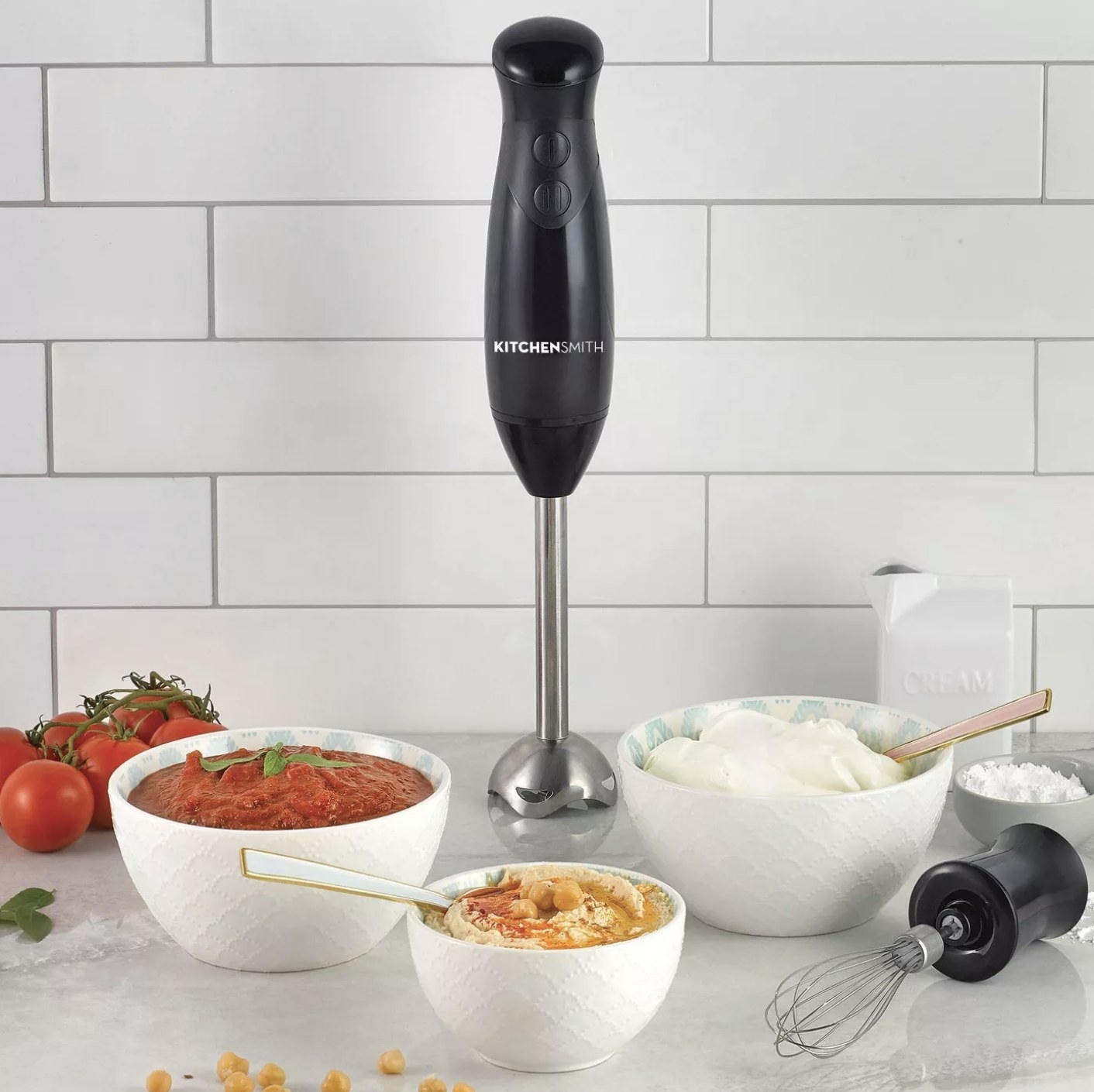 The immersion blender next to bowls of food