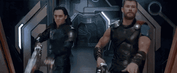 Loki and Thor point their guns and shoot next to each other in Thor: Ragnarok