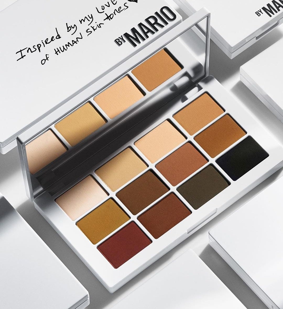 An open eye shadow palette surrounded by closed palettes.