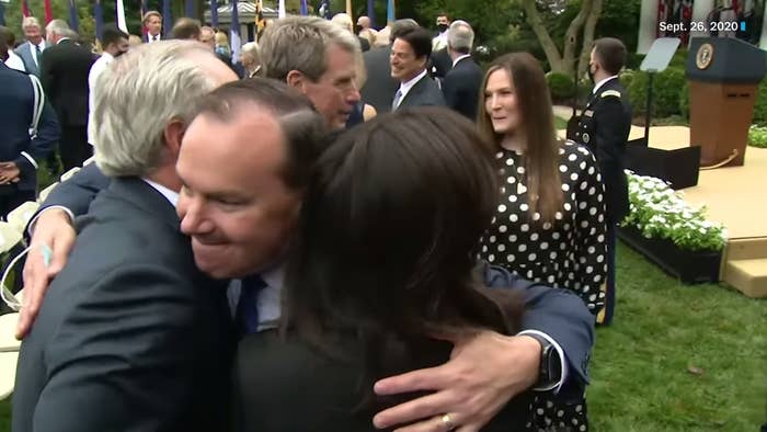 Mike Lee embraces two guests on the Rose Garden lawn 