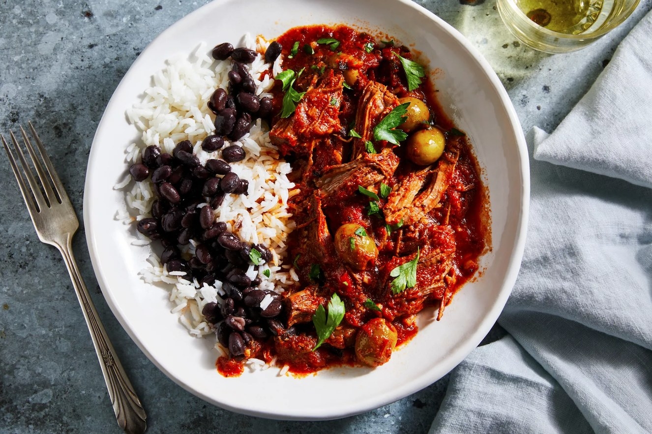 A bowl of ropa vieja served over rice.