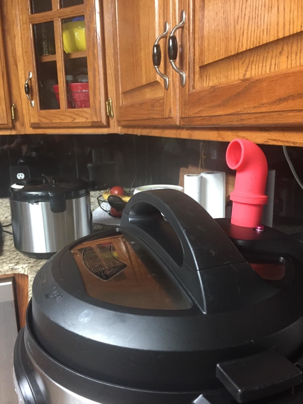 The curved smokestack-like diverter on a reviewer&#x27;s instant pot to point steam away from the cabinets