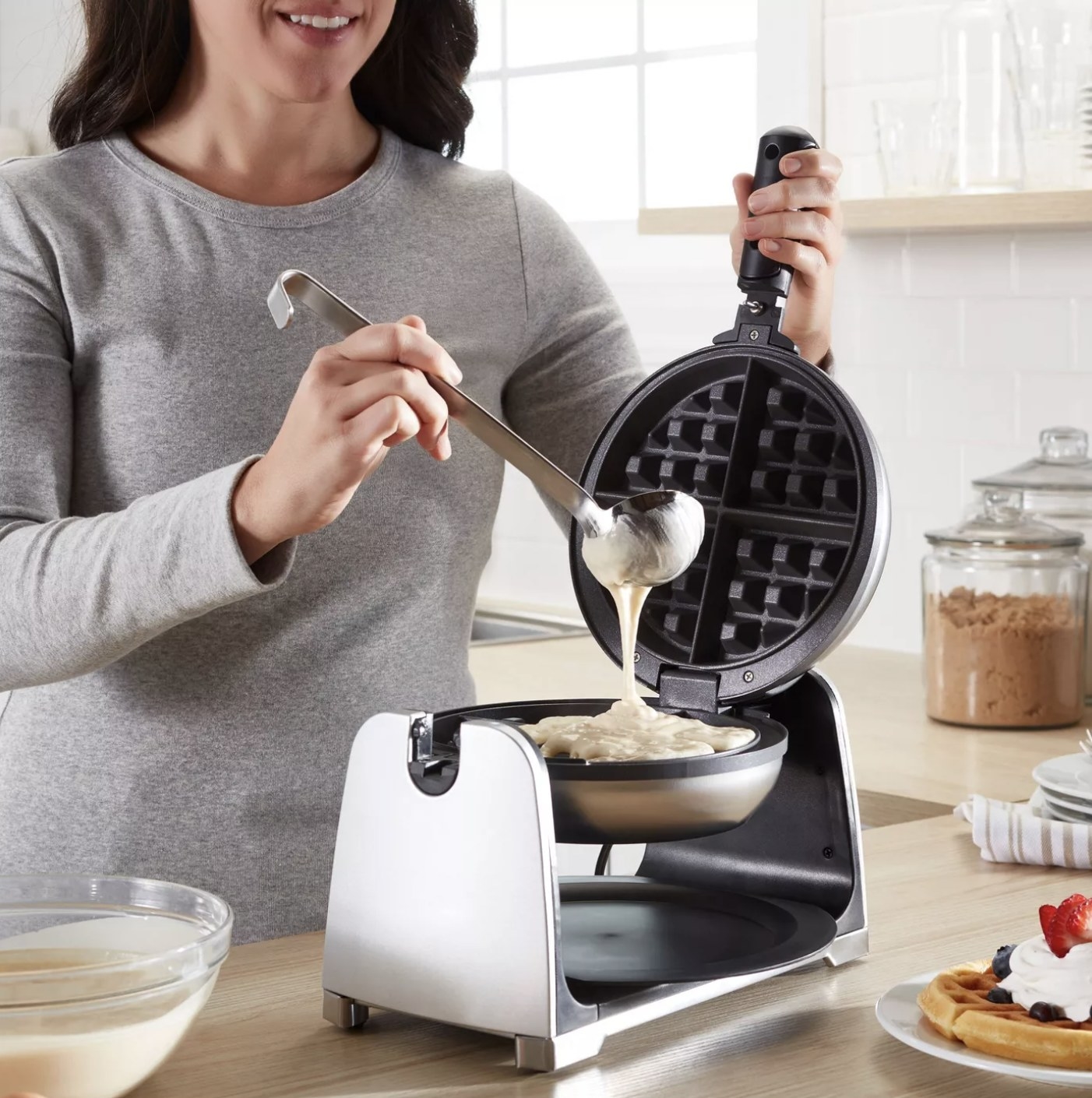Model is pouring the batter into a waffle maker