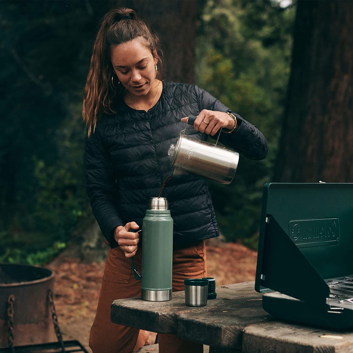 A model pouring a hot beverage into the wide-mouth thermos