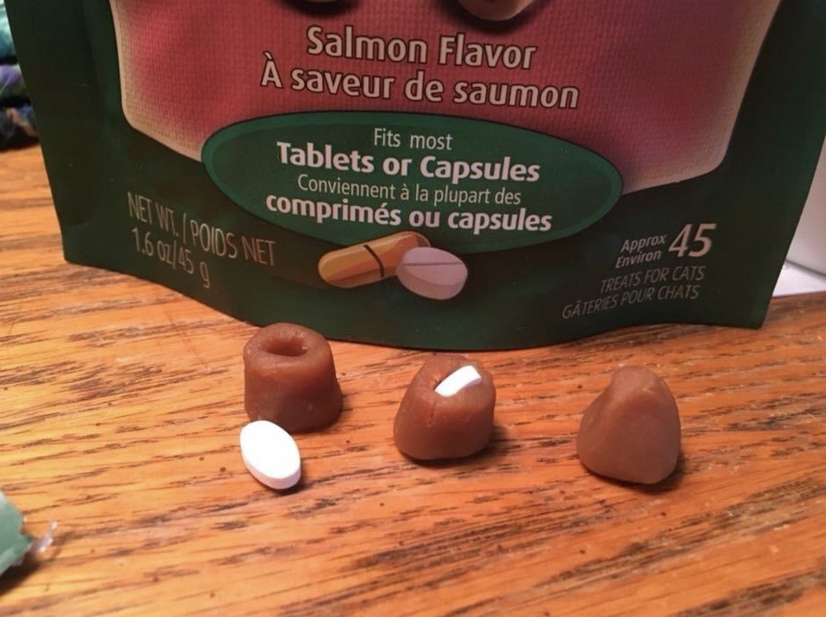 three greenie treats: one with a pill outside of it, one with a pill inside of it, and one with a pill inside of it and the treat molded around the pill so as to hide it