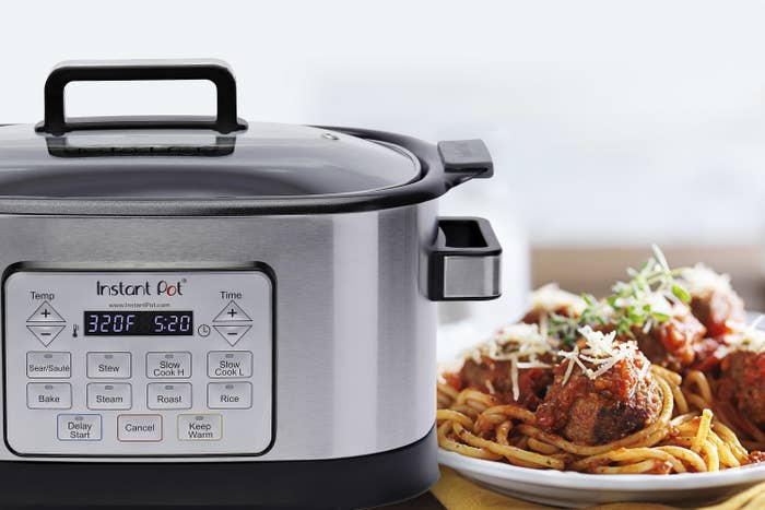 Gray instant pot next to a plate of spaghetti and meatballs
