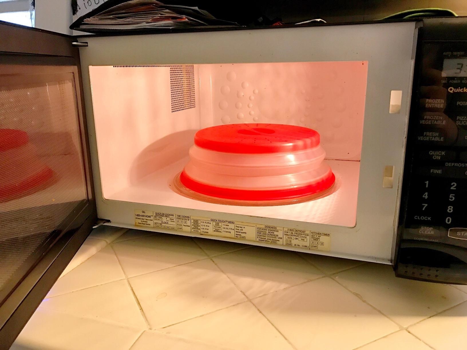A reviewer's photo of the red microwave food cover