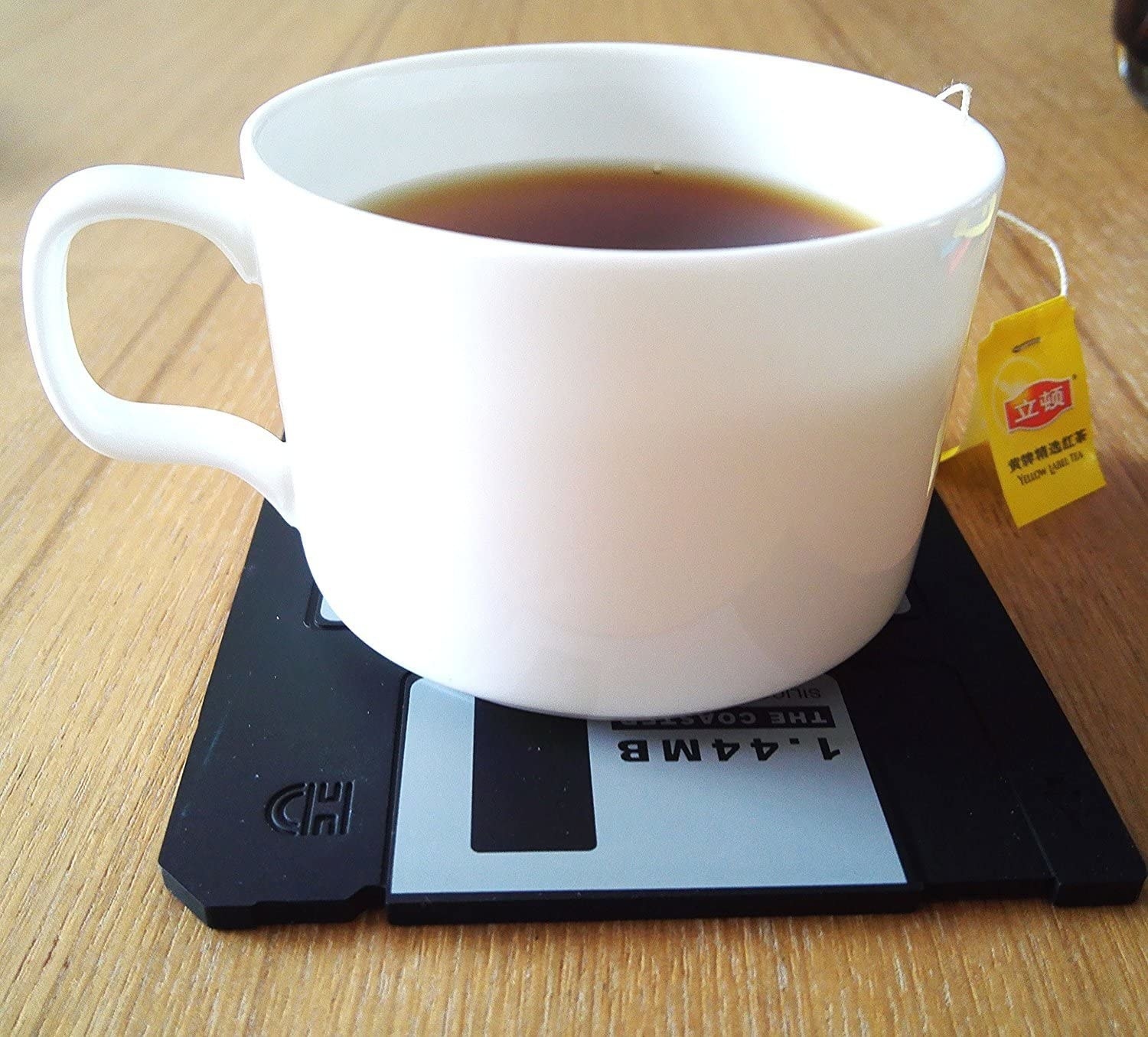 A cup of tea on a black floppy disk coaster 