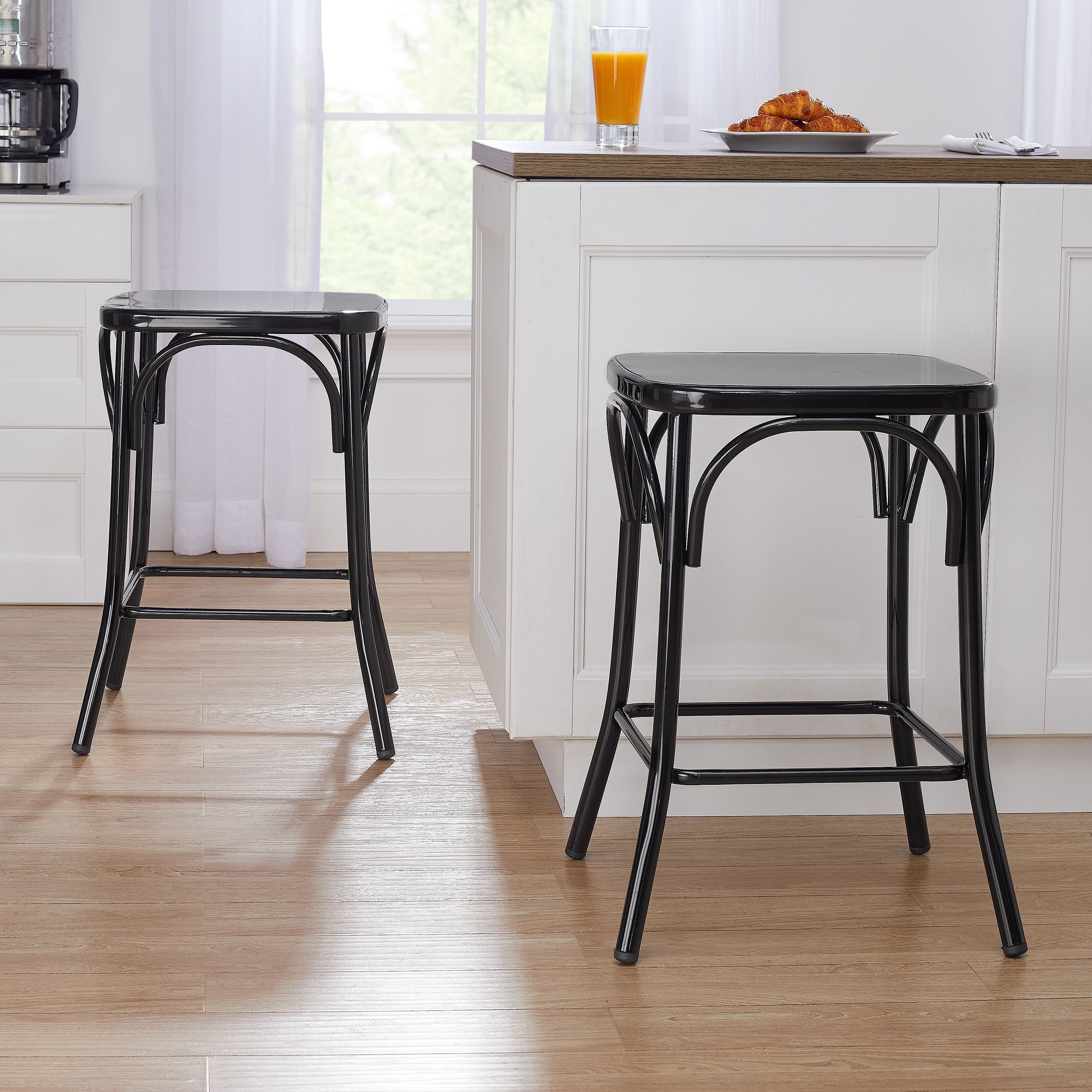 two black counter stools sitting around a kitchen island