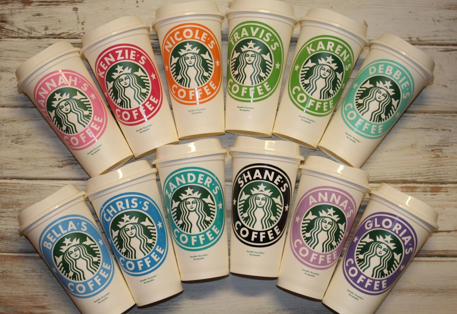 The white cups all with different color rings around the Starbucks logos and a variety of names 
